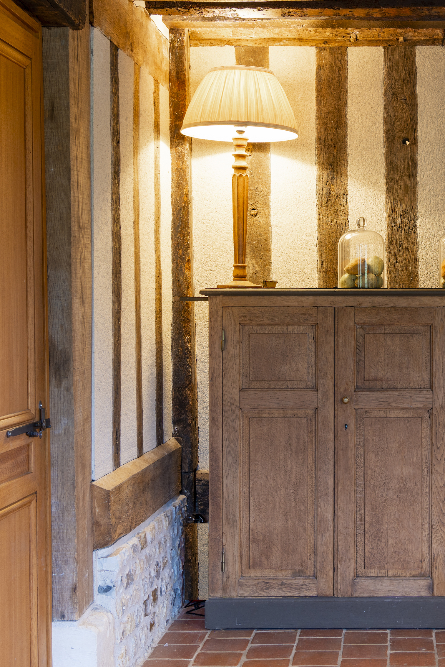 Baja Architecture Réalisation mur avec poutres et décoration d'une lampe posée sur un meuble en bois chez P et P à Bonneville-la-Louvet dans une maison de 260 m2